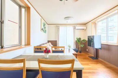 a living room with a table and chairs and a tv at J-2S JR Yamanote Komagome, 3 storey 101sq 4BR, FreePark in Tokyo