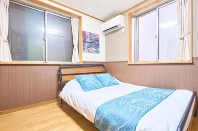 a bed in a room with two windows at J-2S JR Yamanote Komagome, 3 storey 101sq 4BR, FreePark in Tokyo