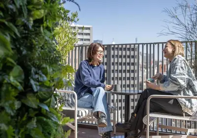 two women sitting on a bench talking at HOTEL GRAPHY Shibuya in Tokyo