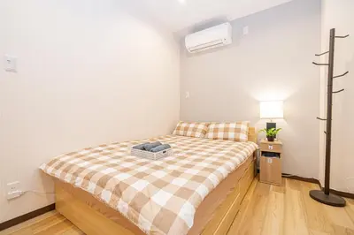 a small bedroom with a bed with a plaid blanket at Asakusa,Ginza,Ueno,Skytree,Stn&Conv 1min ,Family suite,45 Mins to Airport,Kiyoka Villa 清禾 in Tokyo
