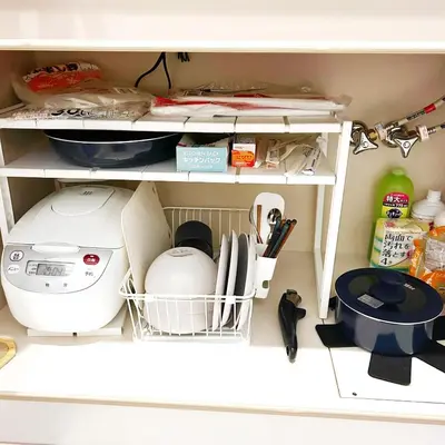 a kitchen cabinet with a shelf with dishes and appliances at LuckyHouse\u6d45\u8349 \u6210\u7530\u7fbd\u7530\u76f4\u884c in Tokyo