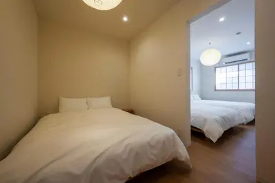 a bedroom with two beds and a mirror at GIVE Kagurazaka in Tokyo