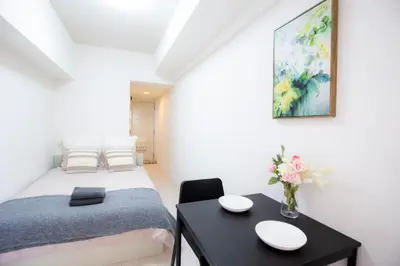 a small bedroom with a bed and a table at Shinjuku Serenity Studio-L06 in Tokyo