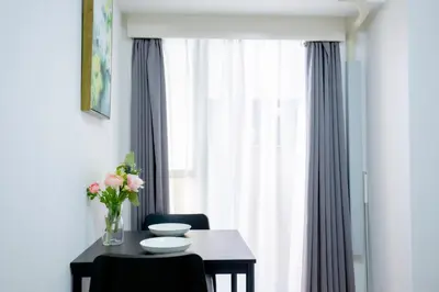 a dining room table with a vase of flowers and a window at Shinjuku Serenity Studio-L06 in Tokyo