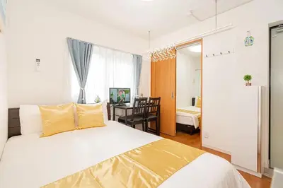 a bedroom with a large bed and a dining room at KYARA Hotel \u4e80\u6238402 in Tokyo