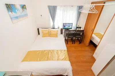a bedroom with a bed and a dining room at KYARA Hotel \u4e80\u6238402 in Tokyo