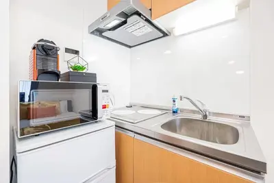 a kitchen with a sink and a microwave at KYARA Hotel \u4e80\u6238402 in Tokyo