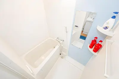 a white bathroom with a sink and a refrigerator at KYARA HOTEL \u4e80\u6238b in Tokyo