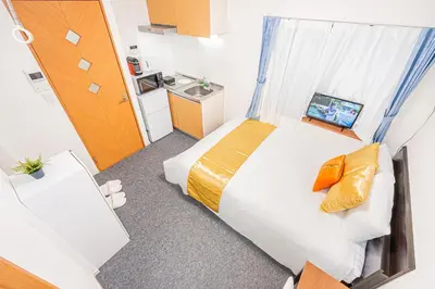 a small bedroom with a bed and a sink at KYARA HOTEL \u4e80\u6238b in Tokyo