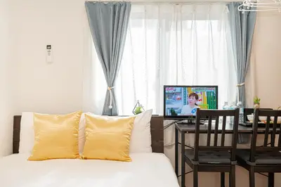 a bedroom with a bed and a desk with a television at KYARA HOTEL \u4e80\u6238b in Tokyo