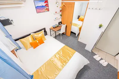 a bedroom with a bed with orange pillows at KYARA HOTEL \u4e80\u6238b in Tokyo