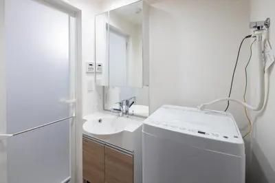 a white bathroom with a sink and a washing machine at Gran Paseo\u795e\u697d\u5742 in Tokyo
