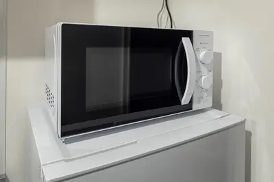 a microwave oven sitting on top of a refrigerator at fl\u30ec\u30b8\u30c7\u30f3\u30b9\u795e\u5bae\u5fa1\u82d1IV in Tokyo