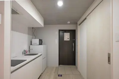 a kitchen with white cabinets and a black door at \u30ec\u30d4\u30e5\u30a2\u66f3\u821f\u30ec\u30b8\u30c7\u30f3\u30b9ll in Tokyo