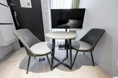 a table and two chairs and a table and a tv at \u30ec\u30d4\u30e5\u30a2\u66f3\u821f\u30ec\u30b8\u30c7\u30f3\u30b9ll in Tokyo