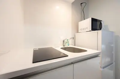 a white kitchen with a microwave and a refrigerator at \u30ec\u30d4\u30e5\u30a2\u66f3\u821f\u30ec\u30b8\u30c7\u30f3\u30b9ll in Tokyo
