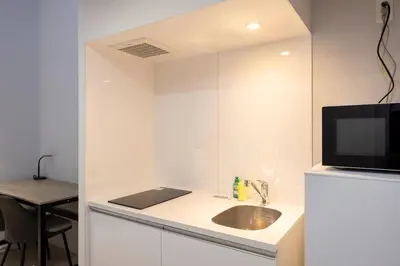 a white kitchen with a sink and a tv at \u30ec\u30d4\u30e5\u30a2\u66f3\u821f\u30ec\u30b8\u30c7\u30f3\u30b9ll in Tokyo