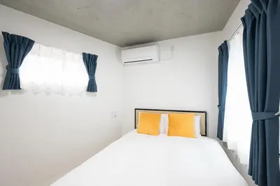 a bed with two orange pillows in a bedroom at Legend COURT\u66f3\u821f in Tokyo