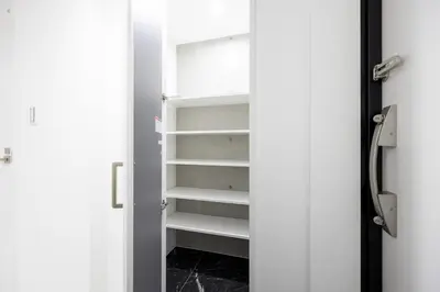 a closet with white shelves and a door at Legend COURT\u66f3\u821f in Tokyo