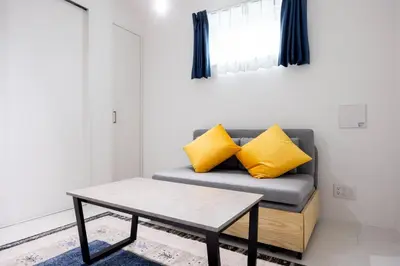 a living room with a couch with yellow pillows at Legend COURT\u66f3\u821f in Tokyo