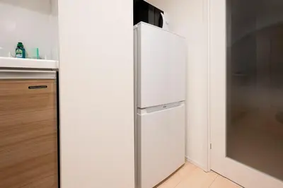 a white refrigerator with a microwave on top of it at MAT SHIBUYAHONMACHI in Tokyo