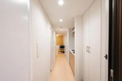 a long hallway with white walls and a white floor at MAT SHIBUYAHONMACHI in Tokyo