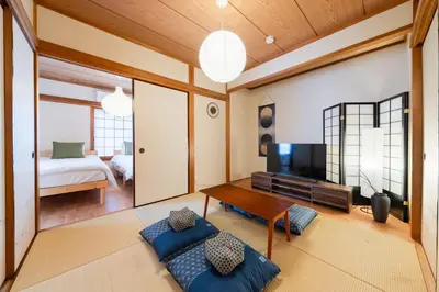 a living room with a television and a bed at SKY Building 201 - Easy Airport Access & Comfortable Stay in Tokyo