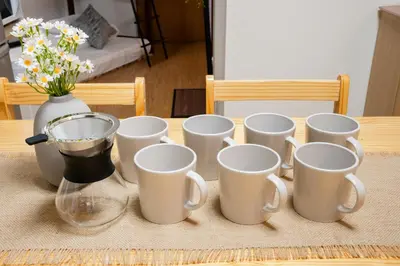 a bunch of white cups on a table with a vase at SKY Building 201 - Easy Airport Access & Comfortable Stay in Tokyo