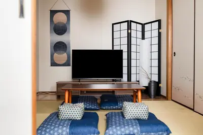 a living room with a tv and a table at SKY Building 201 - Easy Airport Access & Comfortable Stay in Tokyo