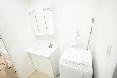 a white laundry room with a sink and a washing machine at 大久保駅から４分、貸切、韓国ダウン至近、新宿/歌舞伎町に徒歩圏内 、단독사용민박 in Tokyo