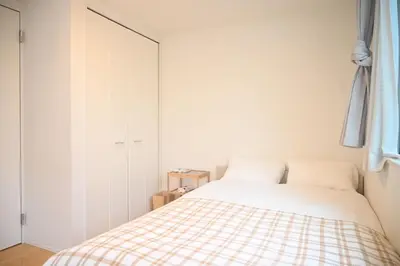 a white bedroom with a bed and a closet at Mi-Villa Pure Gray in Tokyo