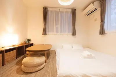 a room with a bed and a table and a desk at Mi-Villa Pure Gray in Tokyo