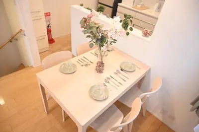 a white table with a vase of flowers on it at Mi-Villa Pure Gray in Tokyo