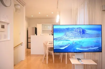 a living room with a flat screen tv on a wall at Mi-Villa Pure Gray in Tokyo