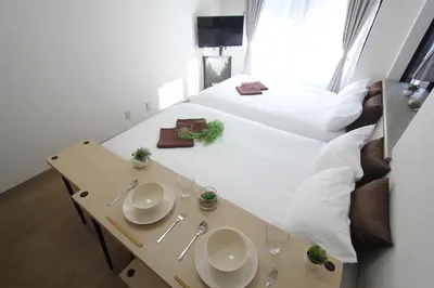 a room with a bed and a table with plates on it at LUANA in SHIBUYA in Tokyo