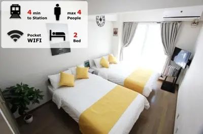 two beds with yellow and white sheets in a room at LUANA in SHIBUYA in Tokyo