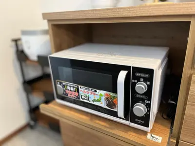 a microwave oven sitting on top of a shelf at Charming New Home Launch: Direct access to Narita & Haneda Airports, Shinjuku, and Disneyland; Close to Asakusa & Akihabara! in Tokyo