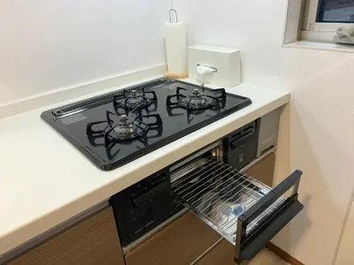 a stove top oven sitting on top of a kitchen counter at Charming New Home Launch: Direct access to Narita & Haneda Airports, Shinjuku, and Disneyland; Close to Asakusa & Akihabara! in Tokyo