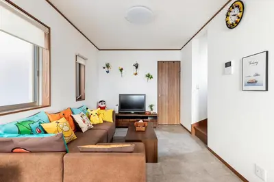 a living room with a couch and a tv at Charming New Home Launch: Direct access to Narita & Haneda Airports, Shinjuku, and Disneyland; Close to Asakusa & Akihabara! in Tokyo