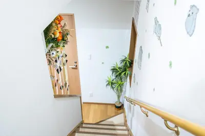 a hallway with a staircase with plants on the wall at \u6771\u4eac\u5409\u4e45\u82b1\u5712\u65c5\u9928 in Tokyo
