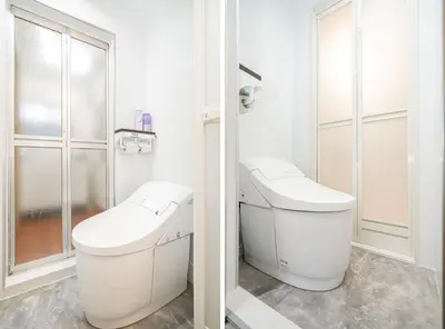 a white bathroom with a toilet and a sink at Sunrise in Tokyo