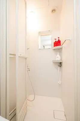 a white bathroom with a shower and a toilet at Sunrise in Tokyo