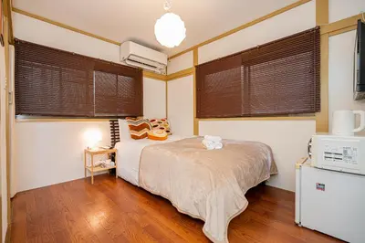a bedroom with a bed and two windows at Sunrise in Tokyo