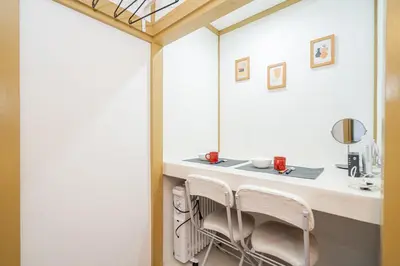 a bathroom with a vanity with two chairs and a mirror at Sunrise in Tokyo
