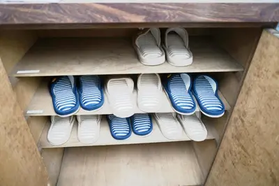 a row of blue and white shoes on a shelf at \u548c\u30ce\u6953cottage\u7b2c\u4e8c\u3000\u65b0\u5bbf\u306e2\u968e\u5efa\u30662\u5ba41\u30b7\u30e3\u30ef\u30fc1\u30c8\u30a4\u30ec in Tokyo