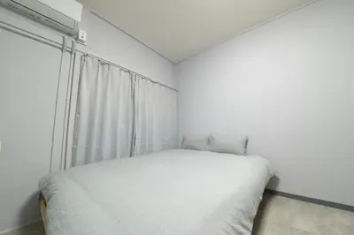 a white bedroom with a bed and a window at \u548c\u30ce\u6953cottage\u7b2c\u4e8c\u3000\u65b0\u5bbf\u306e2\u968e\u5efa\u30662\u5ba41\u30b7\u30e3\u30ef\u30fc1\u30c8\u30a4\u30ec in Tokyo