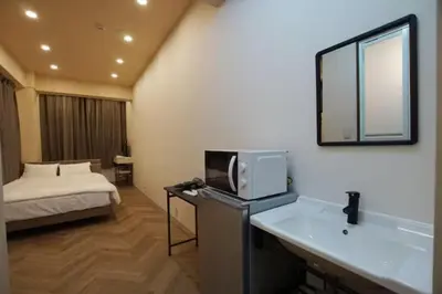 a hotel room with a bed and a microwave at TokyoGuest \u6d5c\u753a in Tokyo