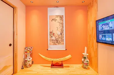 a room with orange walls and a tv and vases at KYARA Hotel\u30df\u30b9\u30df501 in Tokyo