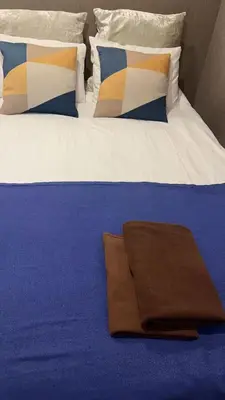 a large bed with a brown blanket on it at Sky \u6674\u7a7a\u5854 \u72ec\u7acb\u53cc\u4eba\u95f4 \u4f46\u662f\u5171\u7528\u6d74\u5ba4\u5395\u6240 in Tokyo