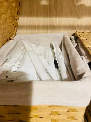 a basket filled with white towels on a bed at Sky \u6674\u7a7a\u5854 \u72ec\u7acb\u53cc\u4eba\u95f4 \u4f46\u662f\u5171\u7528\u6d74\u5ba4\u5395\u6240 in Tokyo